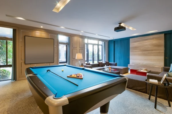 Entertainment room with pool table and large projection screen and seating.